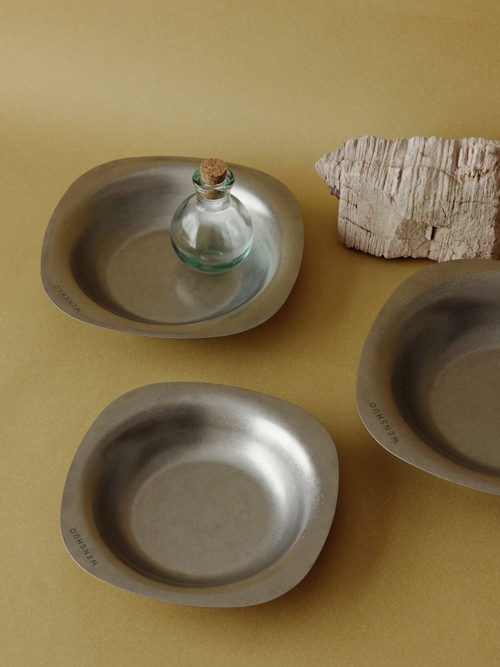 ELOA bowls on a table with a small glass bottle
