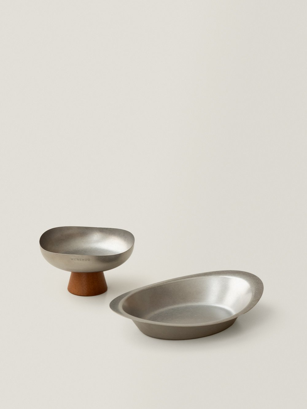 Ova plate beside a Forma pedestal bowl