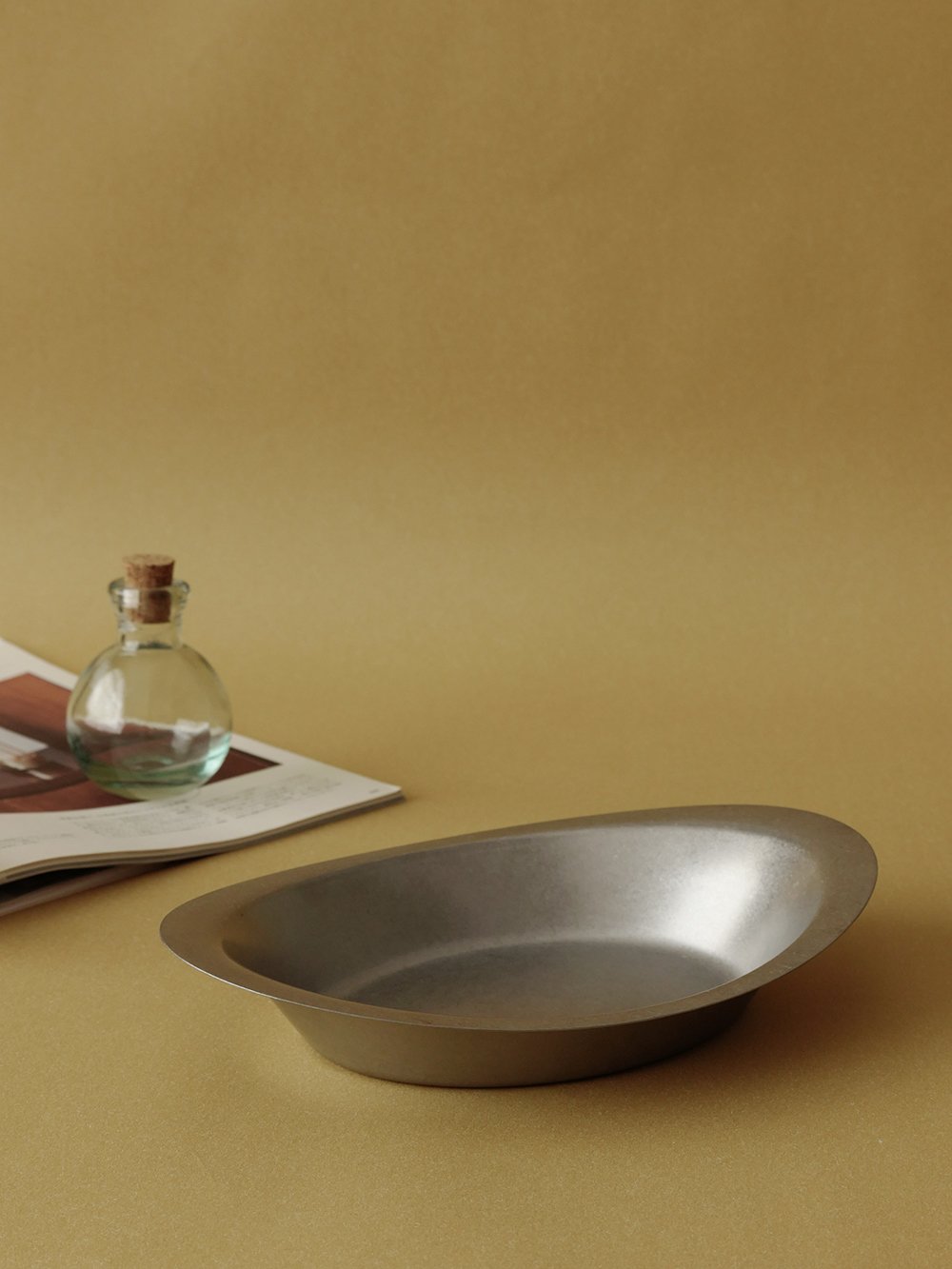 Ova plate on an ochre table, side view of the rim