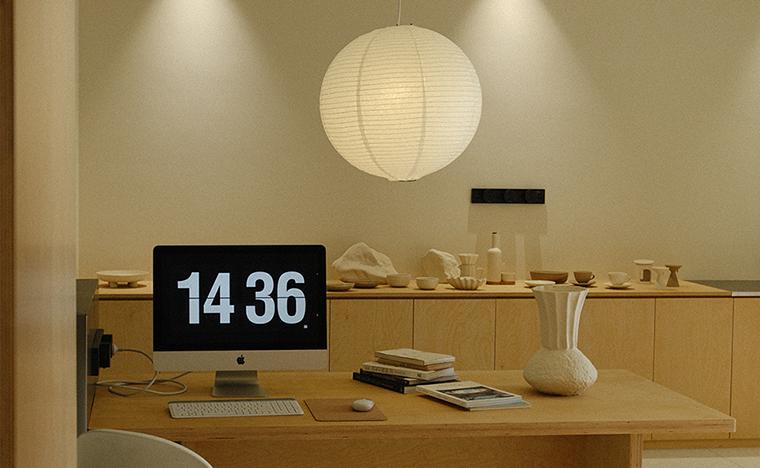 The WENSHUO design studio, with a paper lantern above a long wooden desk